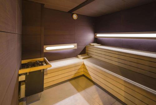 a sauna with wood paneling and a clock on the wall at Château d'Augerville Golf & Spa Resort - TemptingPlaces Collection in Augerville-la-Rivière