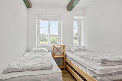 two twin beds in a room with a window at 2804-Romo-Bornholmervej-4 in Høm