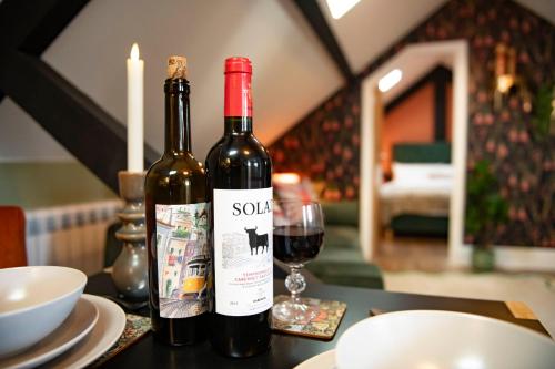 two bottles of wine sitting on a table with a glass at Quirky Apartment in Richmond, North Yorkshire in Richmond