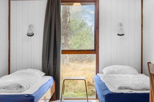 a bedroom with two twin beds and a window at 0418-Romo-Sonderstrandvej-19 in Høm