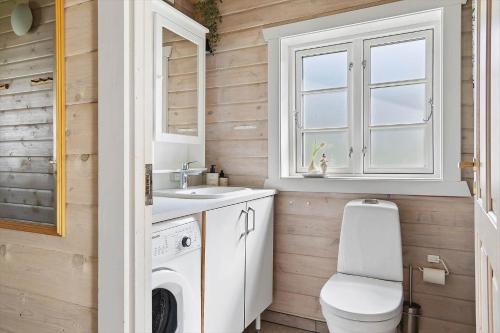 a bathroom with a washing machine and a sink at 0311-Romo-Strandskaden-10 in Høm