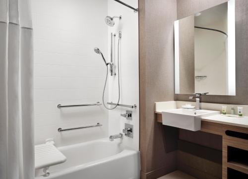 a bathroom with a tub and a sink and a shower at SpringHill Suites by Marriott New Orleans Downtown/Canal Street in New Orleans