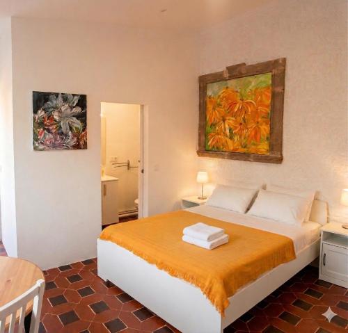 a bedroom with a bed and two paintings on the wall at Open Sky Villa in Denia