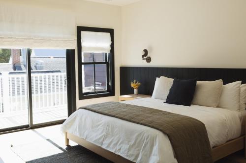 ein Schlafzimmer mit einem großen Bett und einem Balkon in der Unterkunft The Wildset in Saint Michaels