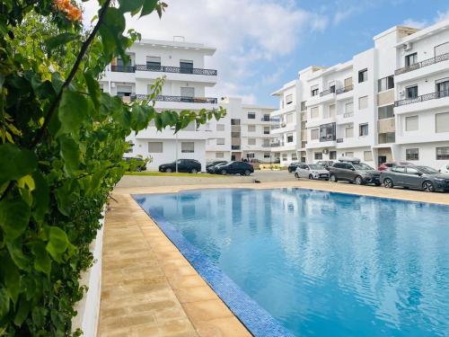 a swimming pool in front of a building at Résidence sable d or in Mansouria