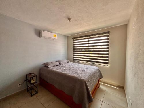 a small bedroom with a bed and a window at New Modern Acapulco Diamante House Getaway with Pool View and Beach Club in Acapulco