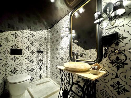 a bathroom with a toilet and a sink and a mirror at Chateau D'Amour Luxury Boutique in Bucharest