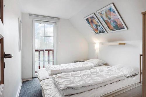 a white room with two beds and a window at 0230-Romo-Havnebyvej-61-E in Høm