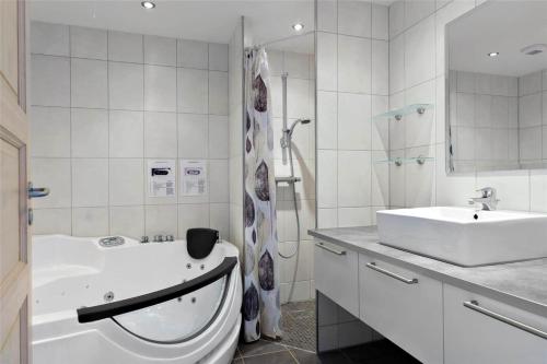 a bathroom with a sink and a toilet and a tub at 0230-Romo-Havnebyvej-61-E in Høm