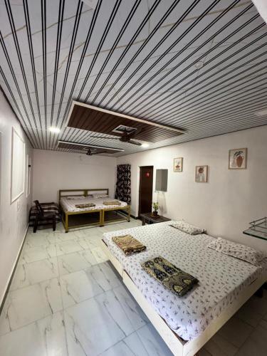a large room with two beds and a ceiling at Shree Savali Cottage in Revadanda