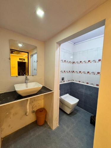 a bathroom with a sink and a toilet and a mirror at Shree Savali Cottage in Revadanda