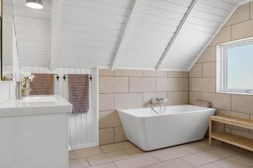 a white bathroom with a tub and a sink at 2600-Romo-Vestergardsvej-18 in Høm