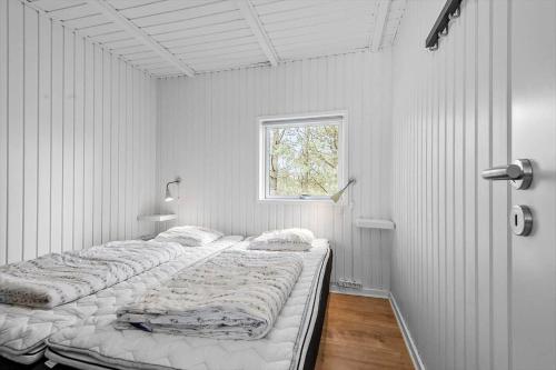 two beds in a white room with a window at 2600-Romo-Vestergardsvej-18 in Høm