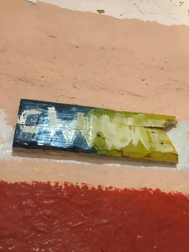 a painting of a paint brush on a wall at Merzouga Hostel in Merzouga