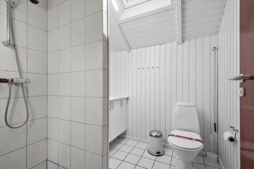 a white bathroom with a shower and a toilet at 0389-Romo-Vestergade-3-Ap-77 in Høm
