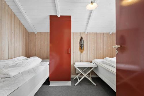 a room with two beds and a red door at 0389-Romo-Vestergade-3-Ap-77 in Høm