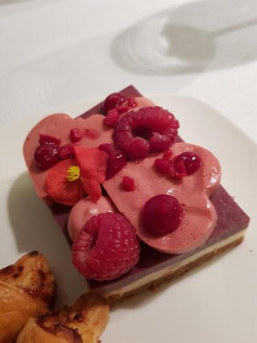 a piece of cake with raspberries on a white plate at La vie Est Belle Vlissingen in Vlissingen