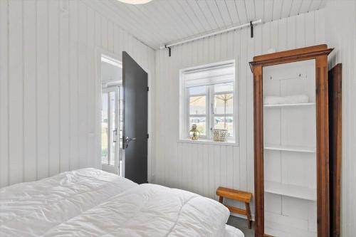 a white bedroom with a bed and a window at 0295-Romo-Vestergade-3-68-E in Høm