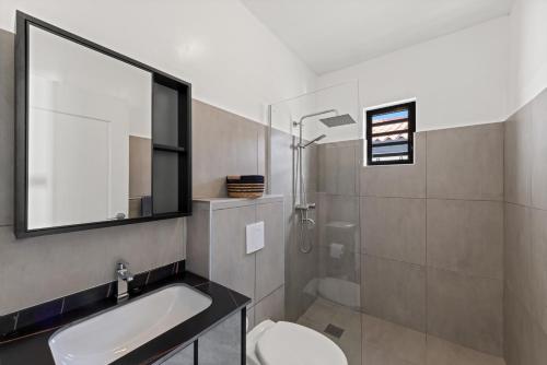 a bathroom with a sink and a toilet and a shower at Tropilena Resort in Willemstad