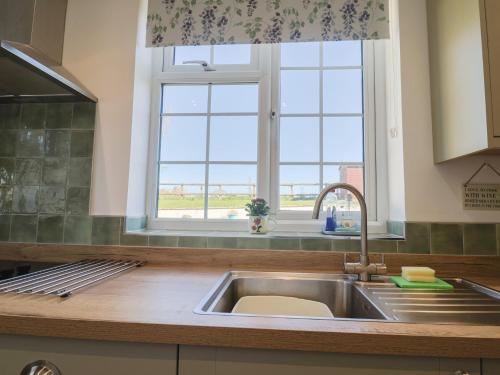 a kitchen with a sink and a window at The Old Smithy in Bridport