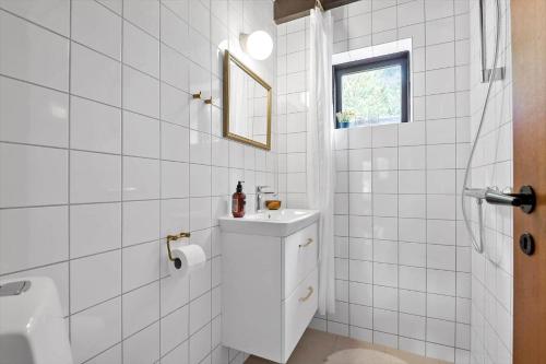 a white bathroom with a sink and a mirror at 0199-Romo-Lejrbjergvej-32 in Høm