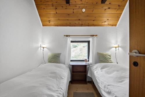 two beds in a small room with a window at 0199-Romo-Lejrbjergvej-32 in Høm