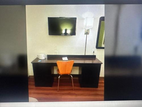 a desk with an orange chair in a room at Motel 6 El Paso East in El Paso