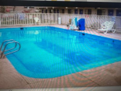 a large swimming pool with blue water at Motel 6 El Paso East in El Paso