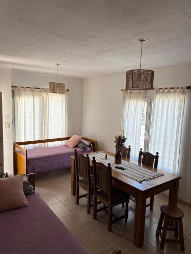 a living room with a table and a bed at Complejo Pampa 1 in Santa Rosa