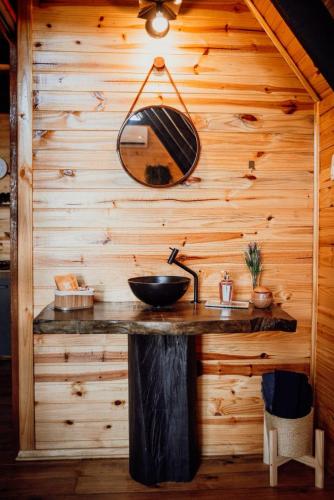 a bathroom with a sink in a wooden wall at Refúgio dos Capitéis Cabana in Farroupilha
