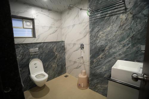 a bathroom with a toilet and a sink at Manasa Comforts Boarding and Lodging Karkala in Kārkāl