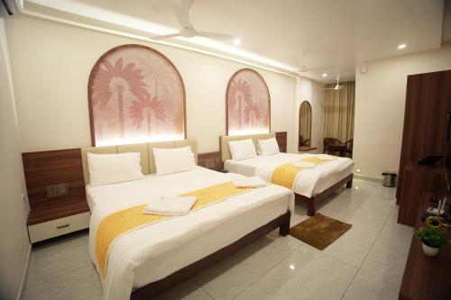 a hotel room with two beds in a room at Manasa Comforts Boarding and Lodging Karkala in Kārkāl