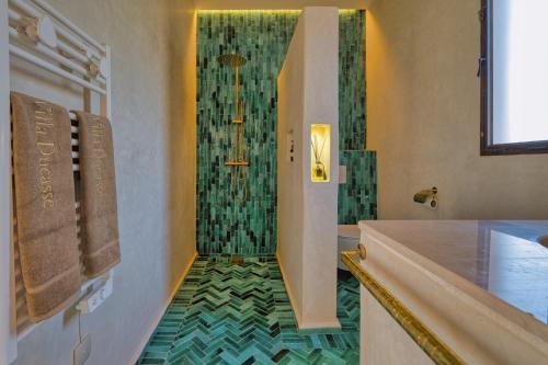 a bathroom with a shower with a green tiled floor at La Villa DUCASSE - Piscine, pétanque, calme à Essaouira in Essaouira