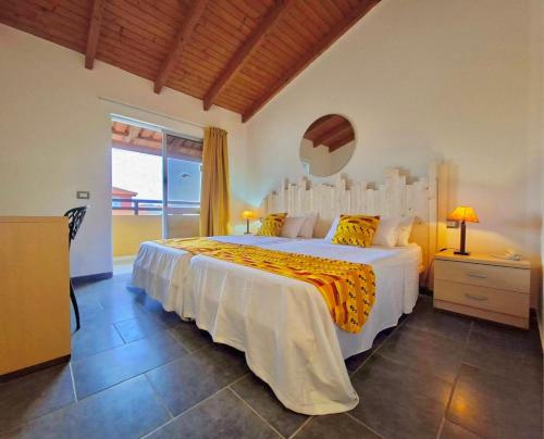 a bedroom with a large white bed and a window at Pensao Porta do Vento in Santa Maria