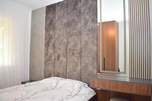 a bedroom with a bed and a dresser and a mirror at Garden apartment in Vala Mar in Hamallë