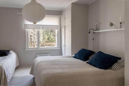 a bedroom with a bed with blue pillows and a window at Seafront Country house with jacuzzi in Salo