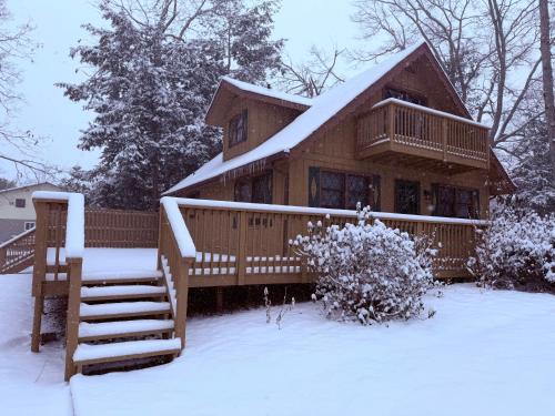 a log cabin in the snow with a porch at The Cozy Chalet in Asheville