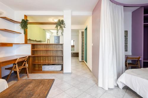 a bedroom and living room with a bed and a desk at Stylish & Colorful Open Space - Sleeps 5 in Manarola