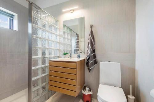 a bathroom with a toilet and a sink and a mirror at 0349-Romo-Vestergade-301 in Høm