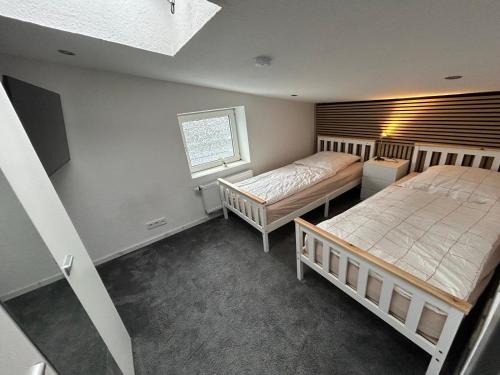 a bedroom with two beds and a window at RosaVilla in Wilhelmshaven