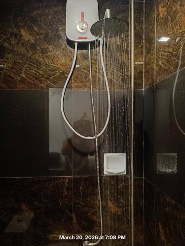 a shower in a bathroom with a glass wall at Chief's Villa Malapascua Island Dorm with Hot Shower & Outdoor Kitchenette in Malapascua Island