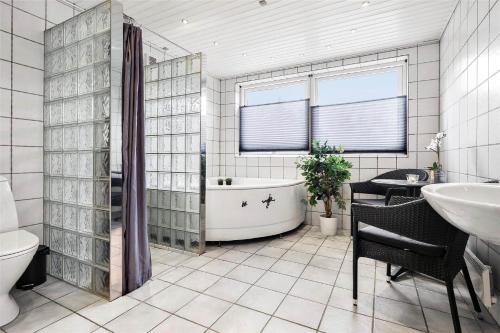 a bathroom with a tub and a toilet and a sink at 0315-Romo-Dyssebjergvej-49 in Høm