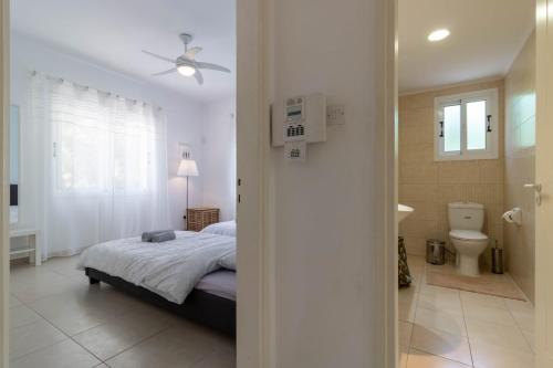 a bedroom with a bed and a bathroom at Villa Isla in Peyia
