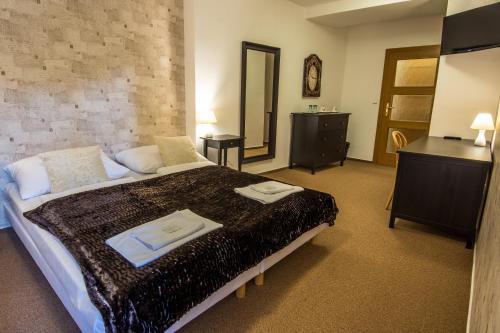a bedroom with a large bed with towels on it at Penzion Fojtstvi in Olomouc
