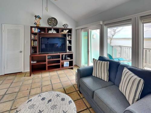 a living room with a blue couch and a tv at Cozy Coastal Repose in Padre Island
