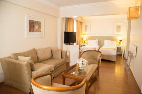 a living room with a couch and two beds at Huentala Hotel in Mendoza