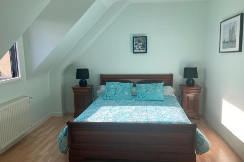a bedroom with a bed with blue pillows at Maison moderne Le doux refuge des pêcheurs près de la mer à Cancale 3 étoiles in Cancale