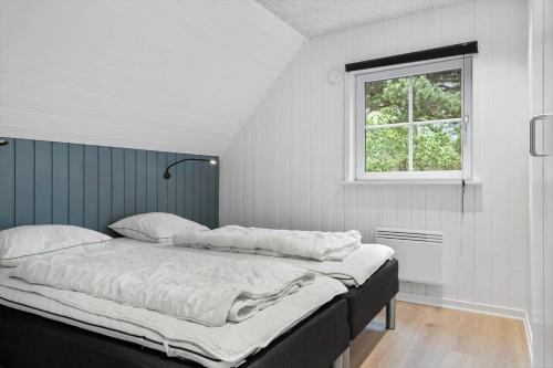 a bed in a room with a window at 0119-Romo-Smafolksvej-43 in Høm