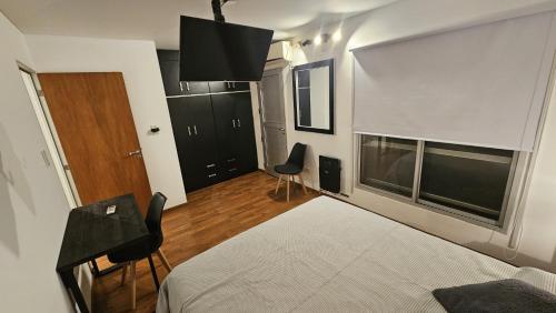 a bedroom with a bed and two chairs and a window at Dúplex Premium Cañada!! in Cañada de Gómez