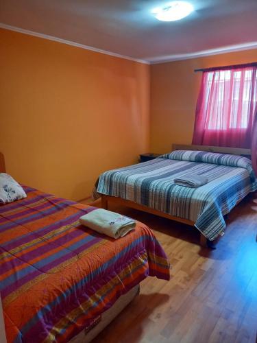 a bedroom with two beds and a window at HOSTAL LA CASONA ALFREDO CAMPOS in Ovalle